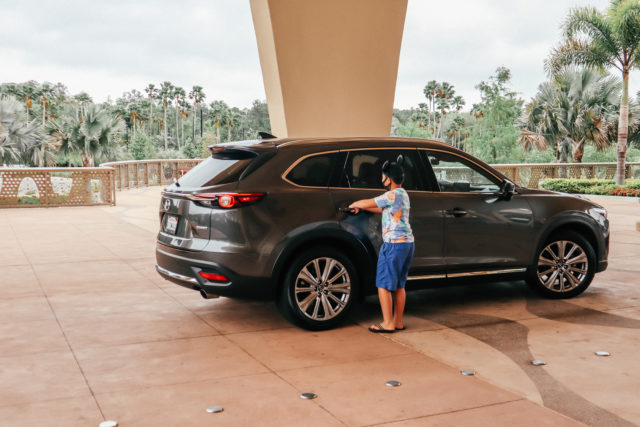 Boy with mouse ears getting into Mazda CX-9