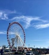 How to plan your family vacation on a budget|A ferris wheel and a blue sky with clouds at a local fair