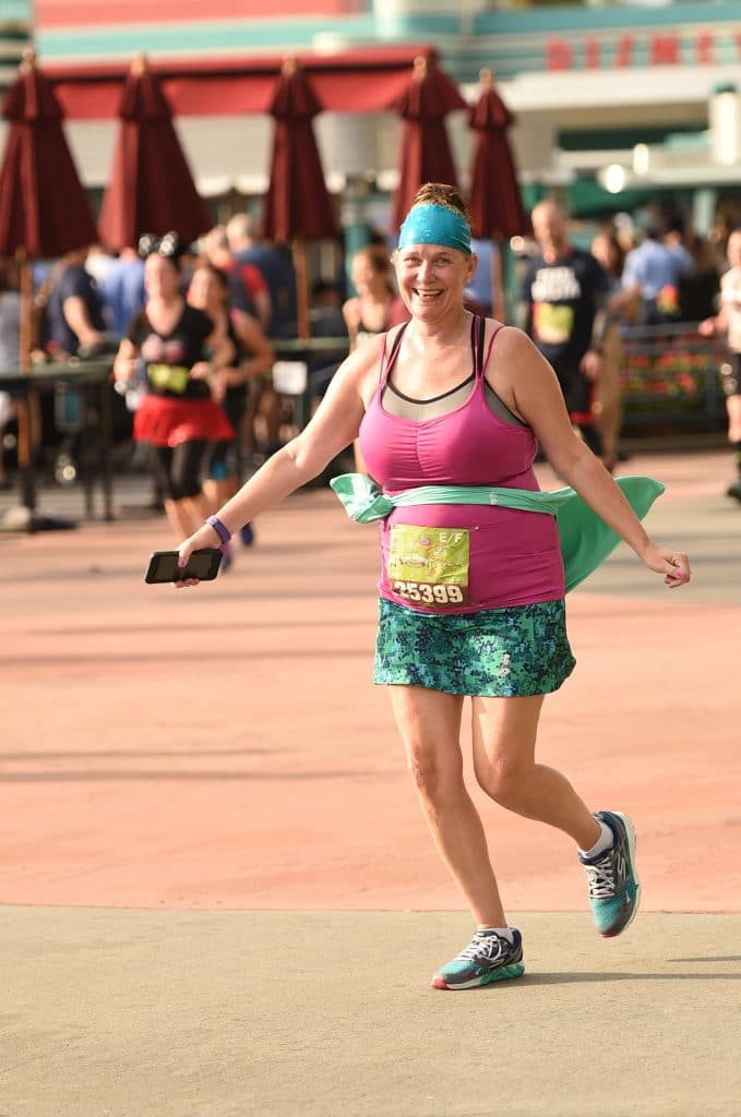 Disney Wine and Dine Half Marathon Weekend - Your Questions Answered|Run Disney Ripped Jeans and Bifocals Smiling woman running in purple top and green skirt