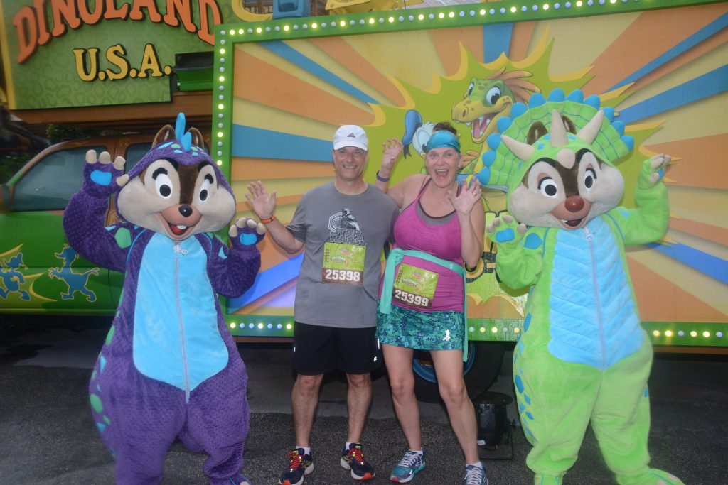 Disney Wine and Dine Half Marathon Weekend - Your Questions Answered|Run Disney Ripped Jeans and Bifocals Man and woman in running clothes with Chip and Dale dressed like dinosaurs