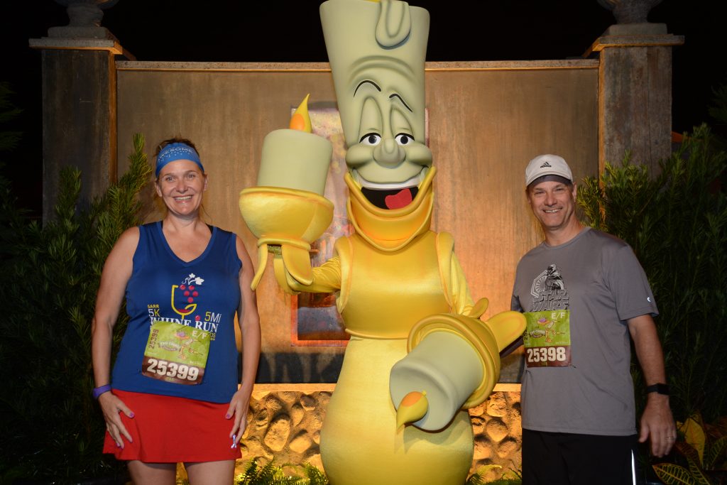 Disney Wine and Dine Half Marathon Weekend - Your Questions Answered|Run Disney Ripped Jeans and Bifocals Man and woman in running clothes with Lumiere from Beauty and the Beast