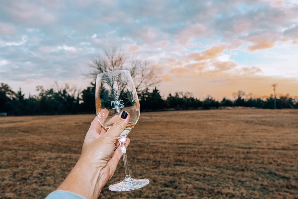 Best places to take Instagram Photos in Decatur Texas|Womans hand with wine glass at sunset at Marker Cellars