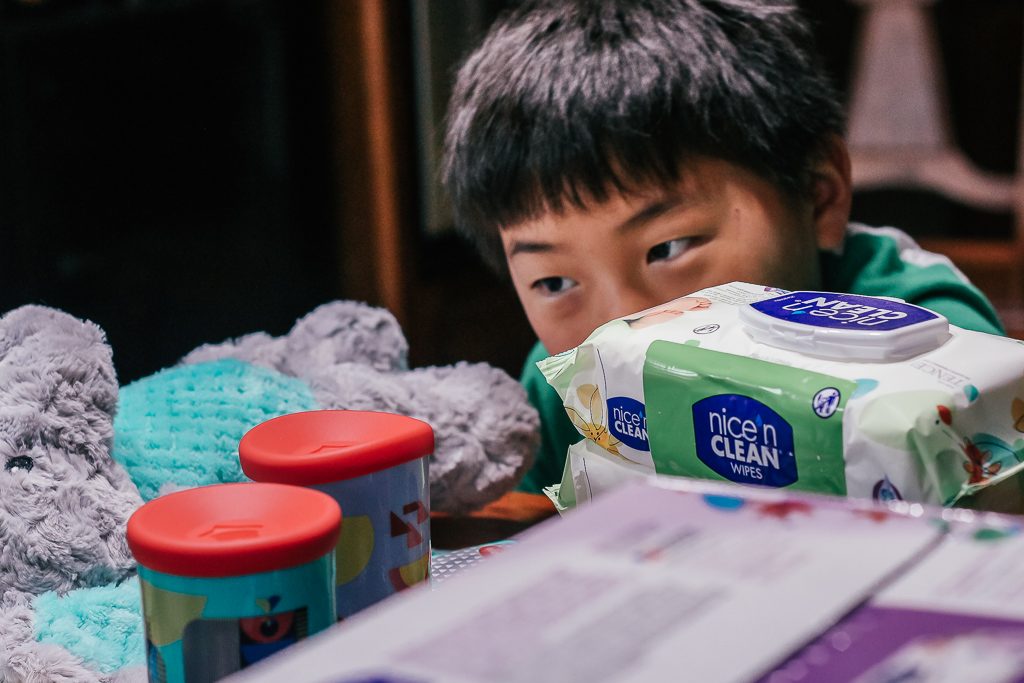 How to get your house ready for a baby...a visiting baby, that is!|Ripped Jeans and Bifocals|Young Asian Boy looking at baby toys on the table with boxes of baby wipes