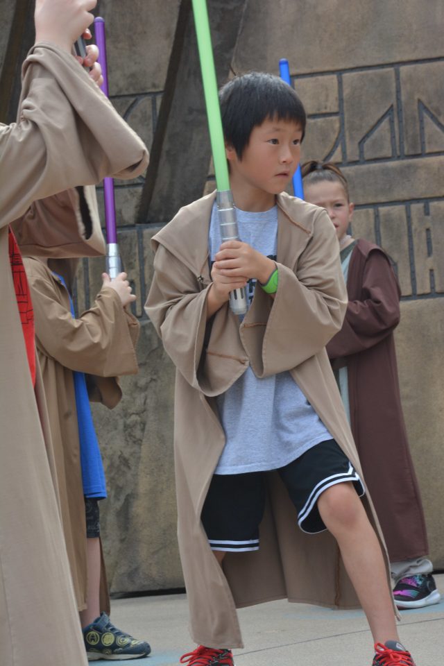 You can sign your kid up for FREE Jedi training? If this isn't a case for Disney World Planning, I don't know what is|Chinese boy with a light sabre