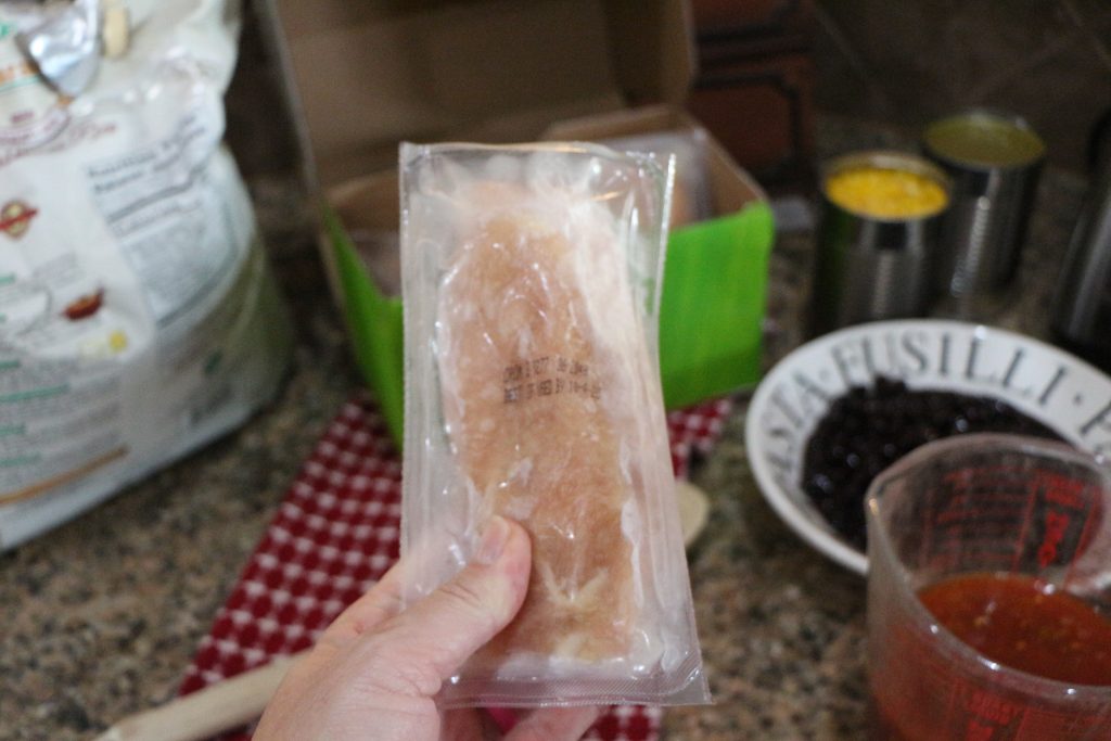 holding package of frozen chicken 