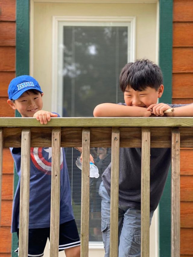 Two boys standing on porch