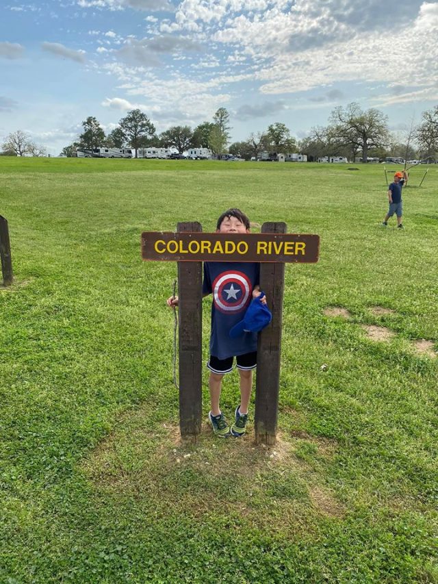 Boy next to Colorado River sign