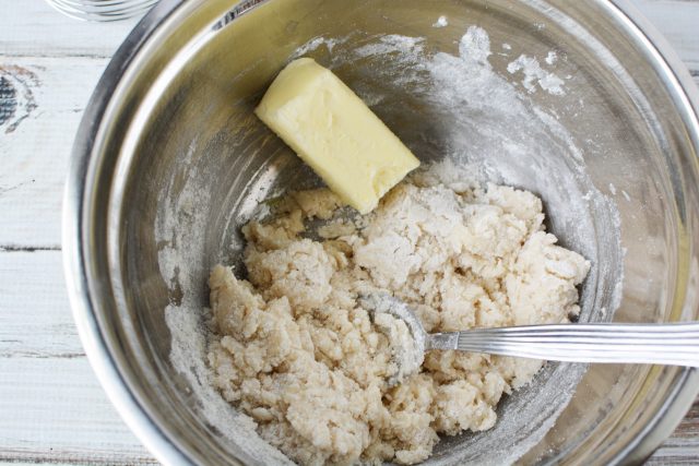 Butter and Bisquick for peach cobbler in a metal bowl