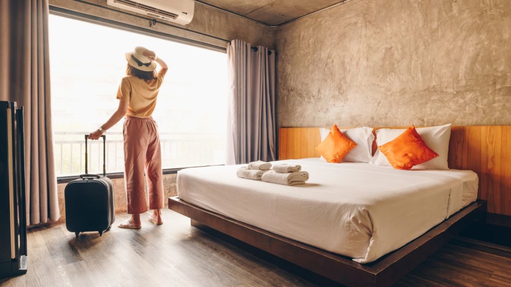 Woman standing at hotel window.