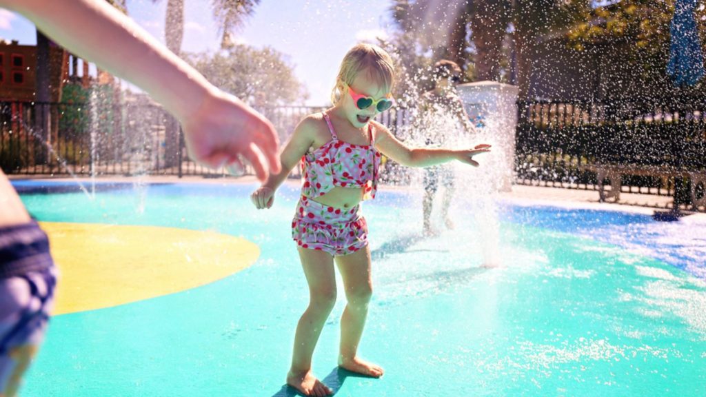 Little girl playing in a splash pad.