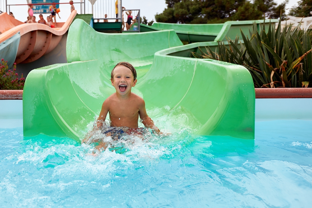 Boy on a green water slide.