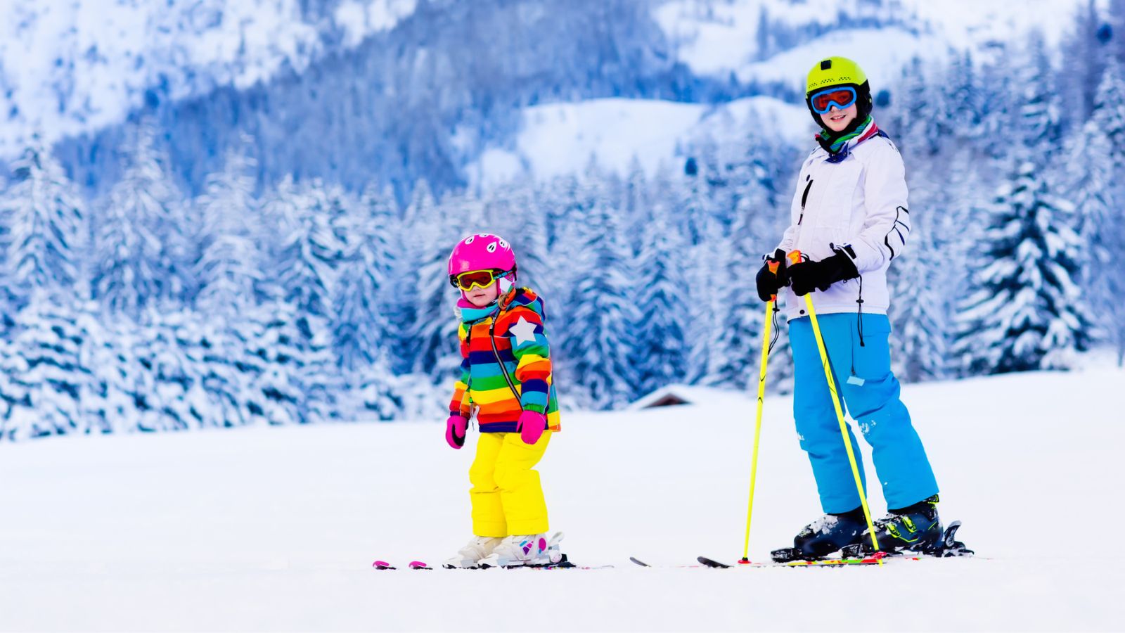 child and instructor in ski school.