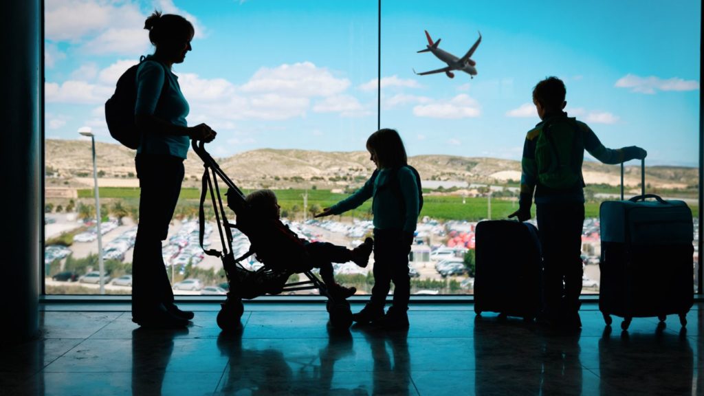 Family in an airport with a stroller.