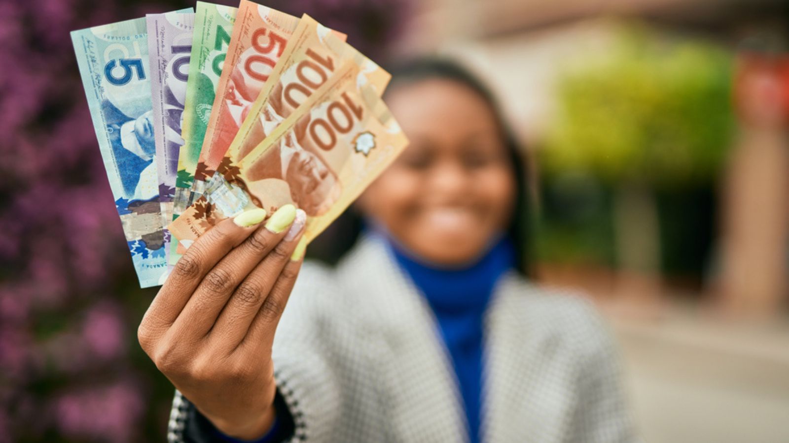 Woman holding Canadian Dollars.