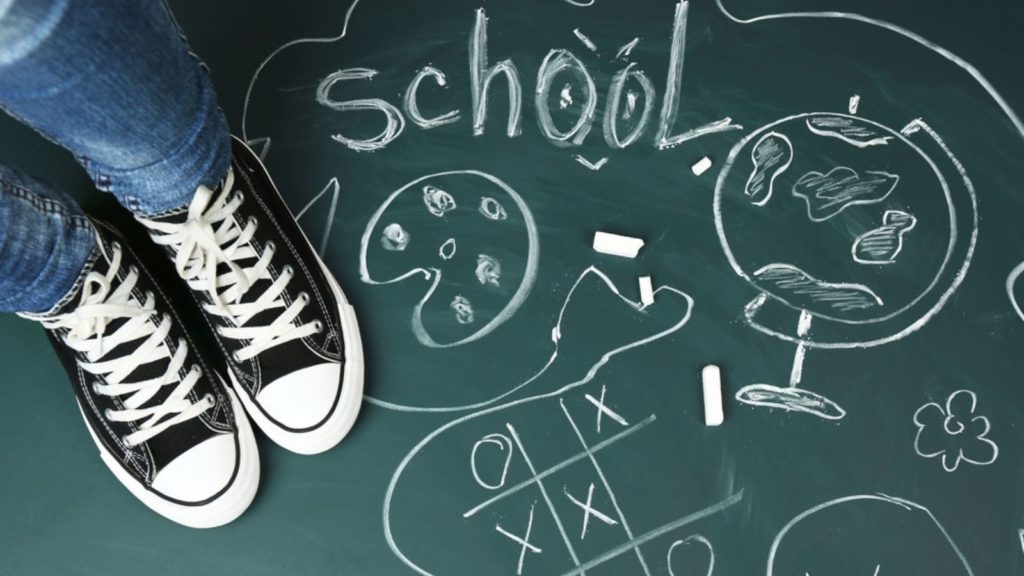 Shoes on a chalkboard back to school.